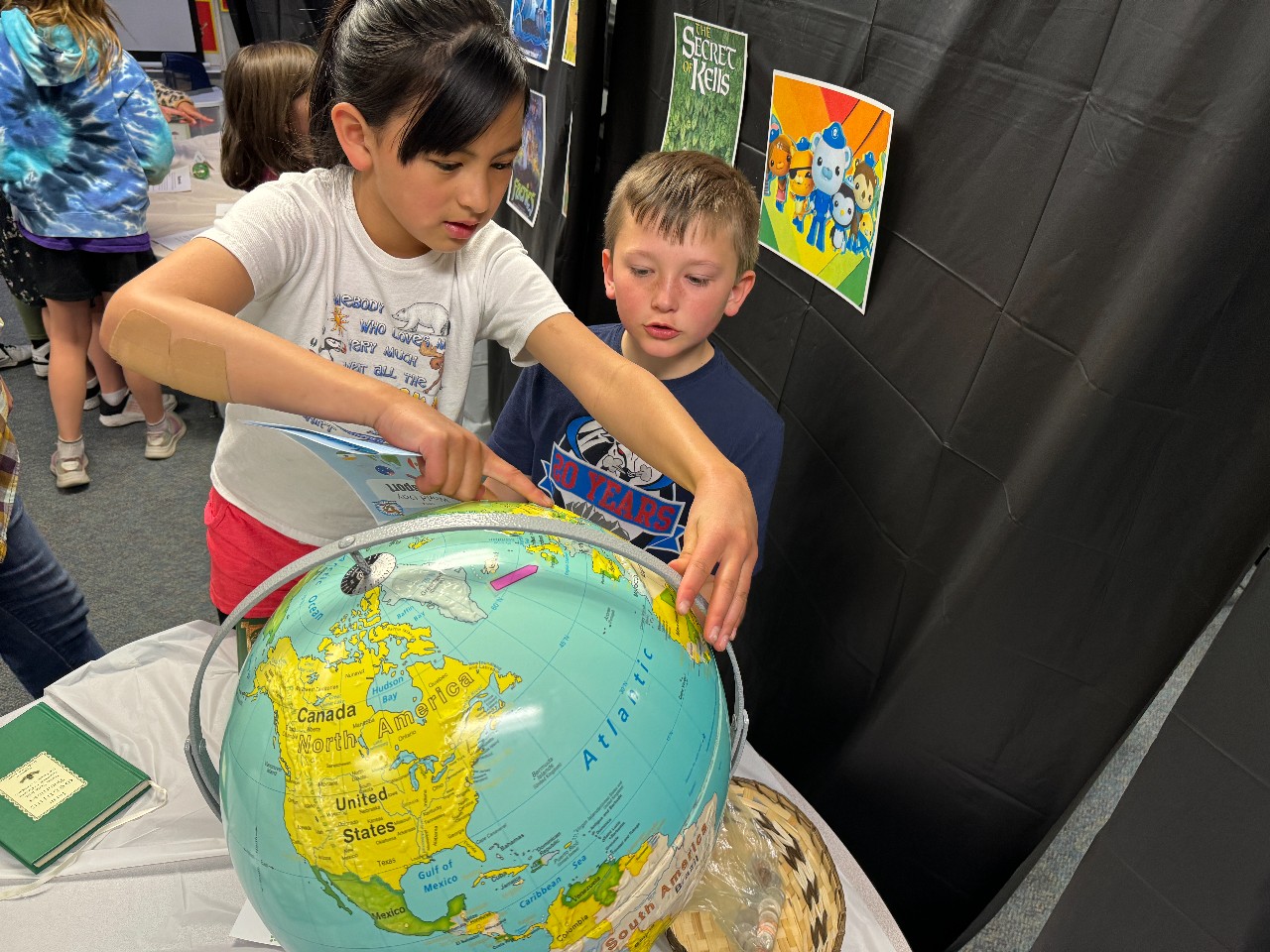 Two students looking at a globe.